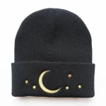 Gorro de lã preta com bordado de lua e estrelas douradas, perfeito para um estilo aconchegante e misterioso.
