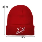 Gorro vermelho de lã com design de um planeta e astros, perfeito para um visual científico e moderno.