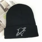 Gorro preto com padrão planetário e estrelas, ideal para os amantes de astronomia e ciências, perfeito para o inverno ou como acessório moderno.