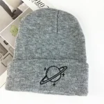 Gorro de lã cinza com logotipo de um planeta rodeado por anéis, perfeito para o inverno ou como acessório de moda científica.