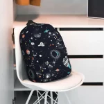 Mochila temática espaço com padrões de planetas, estrelas e galáxias, ideal para estudantes ou amantes de astronomia.