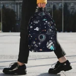Mochila com padrão de espaço e galáxias, perfeita para os amantes de astronomia e decoração científica.