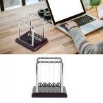 Pêndulo de Newton em metal com base em madeira escura, usado para demonstrações científicas ou como decoração de escritório.
