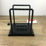 Pêndulo de Newton em madeira e metal, objeto de decoração científica para escritório ou interior.