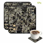 Chip de circuito impresso preto com circuitos dourados, usado como decoração ou objeto científico, acompanhado de uma caneca de café sobre um porta-copos em circuito impresso.