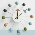 Relógio de parede moderno com esferas coloridas, design minimalista, ideal para decoração interior contemporânea, alia funcionalidade e estilo.