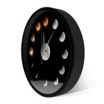 Relógio de parede representando as diferentes fases da lua, com um design minimalista preto e detalhes em tons de cinza e laranja, ideal para decoração científica.