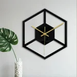 Relógio de parede design em forma de cubo com moldura preta e ponteiros dourados, ideal para uma decoração contemporânea.