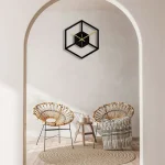 Relógio de parede em forma de cubo com design minimalista, preto e dourado, adicionando um toque contemporâneo à decoração interior.