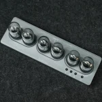 Painel de controle científico com botões esféricos em metal, usado para experiências ou instalações de laboratório.