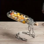 Escultura de garrafa de frutas com corrente de metal, usada como decoração científica ou peça única para um interior original.