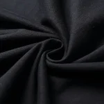 Tecido preto enrolado, textura macia e elegante, ideal para costura e decoração interior.