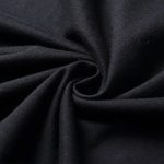 Amostra de tecido preto enrolado, mostrando sua textura suave e fluida, ideal para decoração ou costura.