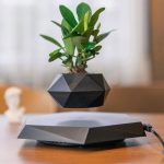 Vaso magnético em levitação com planta verde, decoração inovadora e moderna.