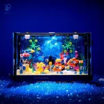 Vitrine de aquário científico com decorações coloridas, peixes de plástico e elementos marinhos, iluminada por uma luz azul para um efeito cativante e educativo.