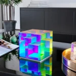 Cubo luminoso de acrílico com efeitos de cores vivas, ideal para decoração de escritório ou espaço científico.
