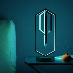 Chave LED moderna em forma de chave, iluminada por uma luz azul, colocada sobre uma mesa com um pequeno vaso e um livro, decorativa e inovadora para um interior científico ou tecnológico.