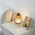 Lâmpada de mesa em madeira e papel japonês, iluminando suavemente um canto do quarto com uma atmosfera acolhedora e natural.