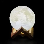 Lâmpada lua 3D realista sobre suporte em madeira, iluminação suave, decoração de interiores inspirada na astronomia, ideal para uma atmosfera acolhedora e cósmica.