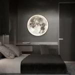 Lâmpada de parede em forma de lua cheia iluminando um quarto moderno com uma parede cinza escura, criando um ambiente relaxante e misterioso.