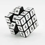 Cubo puzzle numerado em plástico preto e branco, perfeito para estimular o raciocínio e a lógica, ideal como decoração científica ou objeto educativo.