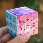 Cubo educativo com elementos químicos como Hidrogênio, Carbono e Nitrogênio, usado para aprendizagem científica e decoração.
