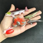 Coleção de figuras de peixes e criaturas marinhas em plástico colorido, ideais para decoração científica ou educativa.