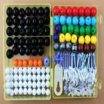 Bolinhas coloridas de plástico com acessórios para jogos educativos e atividades manuais.