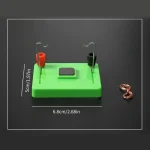 Chip de demonstração de circuito elétrico com fios, ímãs e base de plástico verde, usado para experiências científicas educativas.