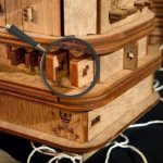 Ponteiro sobre um quebra-cabeça de madeira com uma lupa para explorar os detalhes.
