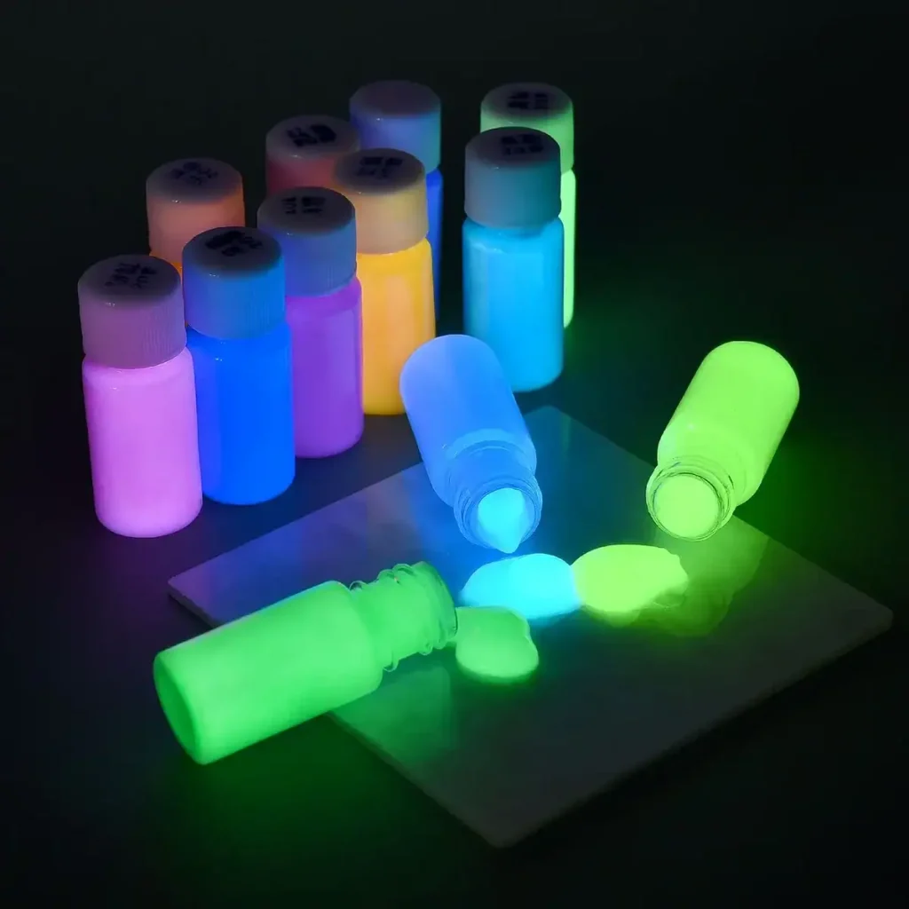 Frascos de tinta fosforescente fluorescente emitindo uma luz viva no escuro, perfeitos para decoração e projetos artísticos luminosos.