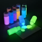 Frascos de tinta fosforescente fluorescente emitindo uma luz viva no escuro, perfeitos para decoração e projetos artísticos luminosos.