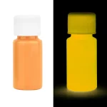 Pílulas fluorescentes laranja e amarelas sob luz negra, ilustrando a fluorescência em um ambiente escuro.