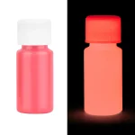 Garrafa de tinta fosforescente rosa visível em luz normal e sob luz UV, ilustrando a diferença de aparência no escuro.