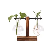 Suporte de plantas suspensas com dois frascos de vidro contendo plantas verdes.