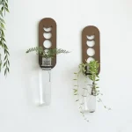 Suporte decorativo de vasos em metal com design inspirado nas fases lunares, contendo plantas verdes para um toque natural e moderno.
