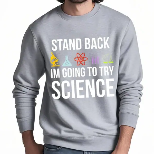 Camisola cinza com mensagem humorística "Afastem-se, vou tentar ciência" e ícones de laboratório coloridos, perfeita para amantes de ciência e piadas.