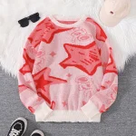 Camisola de malha rosa com padrões de estrelas e rosto de gato vermelho, ideal para um visual casual e moderno.