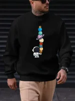 Sweatshirt preta com padrão de planetas coloridos empilhados e um pequeno astronauta, ideal para os amantes de ciência e astronomia. Confortável e na moda, perfeito para um look descontraído.