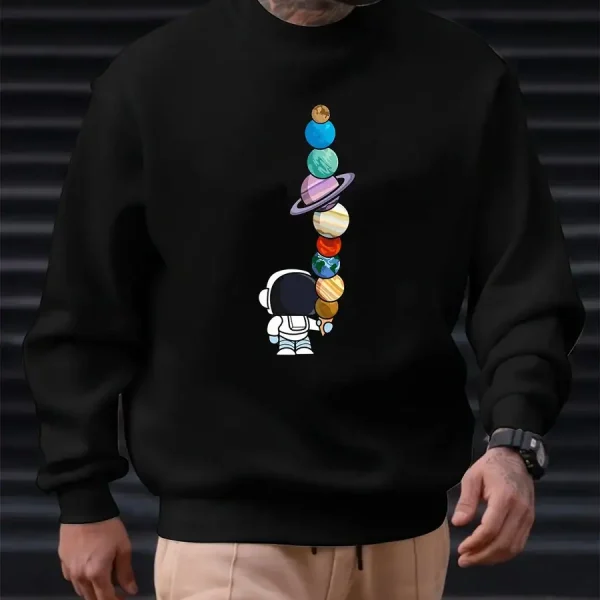 Sweatshirt preta com padrão de planetas coloridos empilhados e um pequeno astronauta, ideal para os amantes de ciência e astronomia. Confortável e na moda, perfeito para um look descontraído.