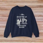 Sweatshirt azul-marinho com design científico, ilustração de mulher e animais, texto humorístico "Beam me up, this place sucks" para os amantes de ciência e estilo irreverente.