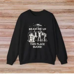 T-shirt preta com ilustração humorística e texto "Beam me up, this place sucks!" para os amantes de ciência e humor.