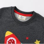 T-shirt cinza escuro com estampa de foguete colorido, estrelas e elementos científicos, perfeita para os amantes de ciência e astronomia.