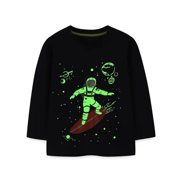 Camisola preta com ilustração de uma criança em traje espacial sobre uma prancha de surf no espaço, rodeada de planetas, estrelas e meteoros.