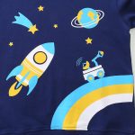 Painel infantil com padrão espacial, foguete, planeta e estrelas coloridas.