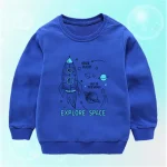 Roupa infantil com estampa de foguete e planetas, tema de exploração espacial.