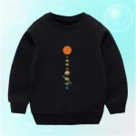 Roupa para criança preta com padrão de planetas do sistema solar alinhados verticalmente, representando diferentes planetas da nossa galáxia, ideal para amantes de astronomia e ciências.