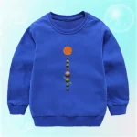 Camisola azul para criança com padrão planetário representando o Sol e os planetas do sistema solar.