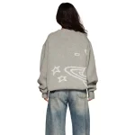 Casaco cinza oversized com padrões de estrelas e galáxia, ideal para um look descontraído e moderno, vista de costas.