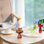 Vasos de vidro em forma de cogumelos com flores coloridas sobre uma mesa de madeira, decoração de estilo científico e moderno.